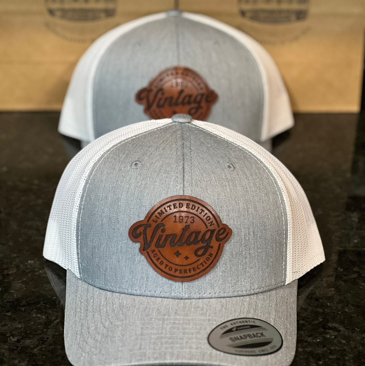 Heather and white trucker hats with round Vintage patches